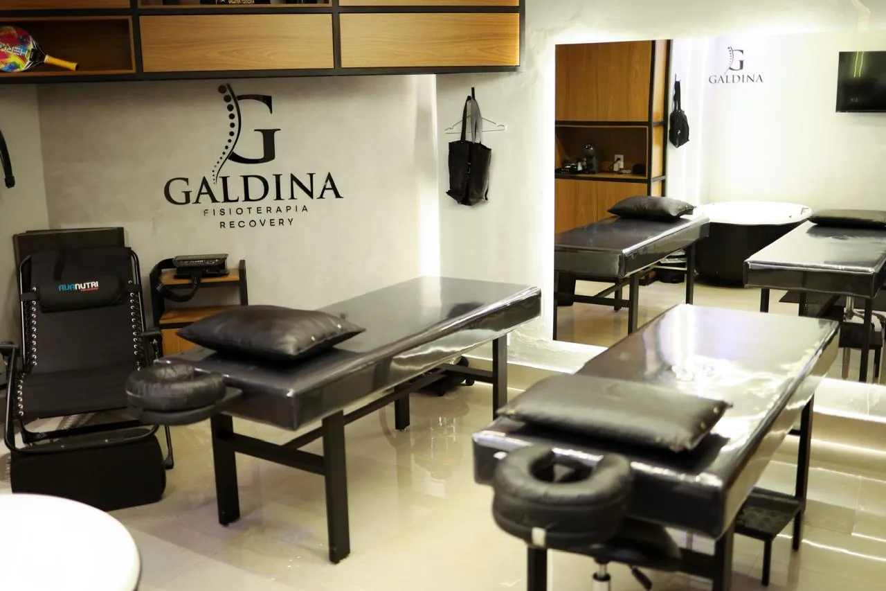 Sala de atendimento Galdina com macas e logo na parede